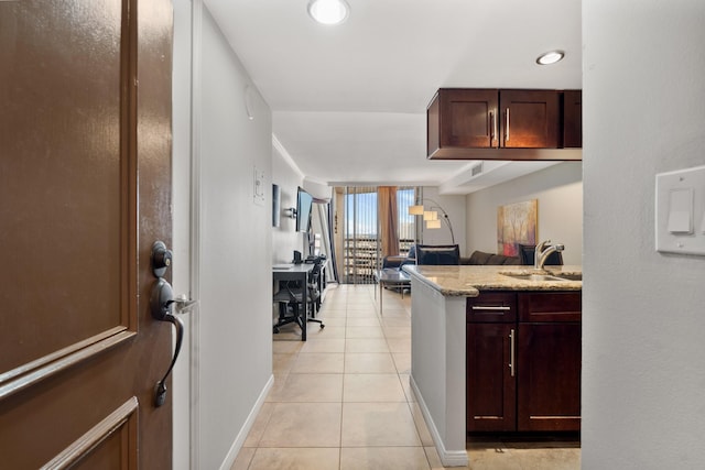 kitchen with light stone counters, sink, and light tile patterned floors