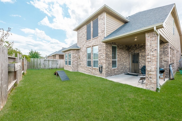 rear view of house with a lawn and a patio area