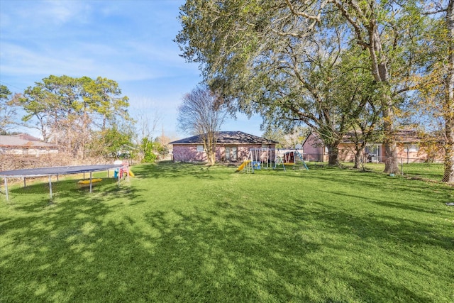 view of yard featuring a playground and a trampoline