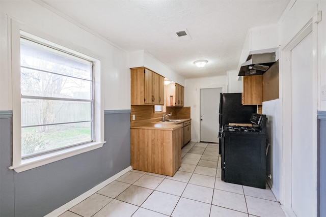 kitchen featuring light tile patterned flooring, sink, ventilation hood, a textured ceiling, and black appliances