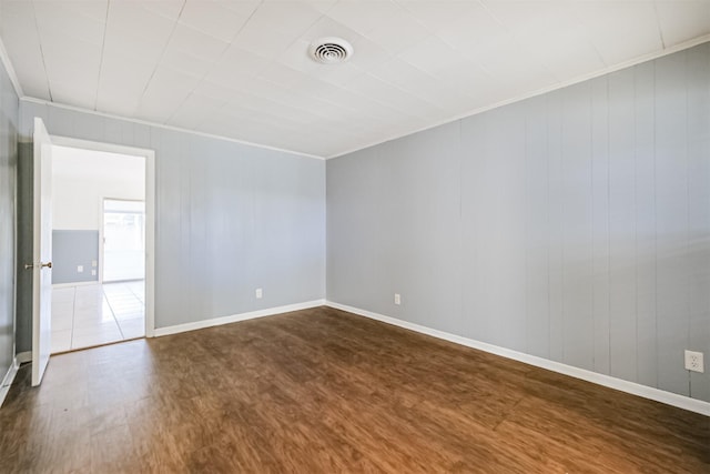 empty room featuring wood-type flooring and ornamental molding