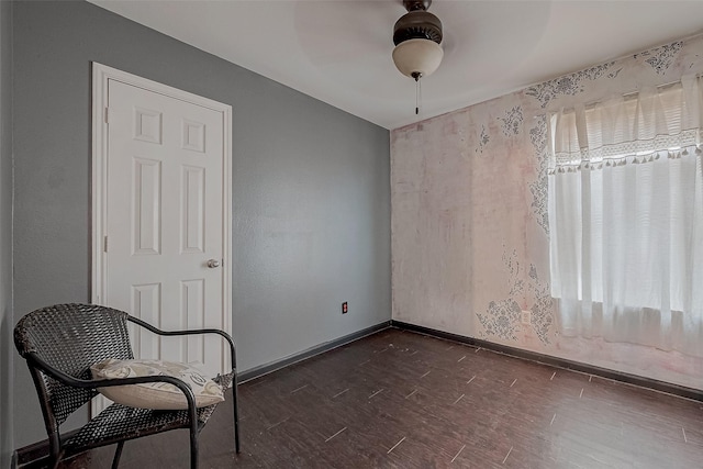 living area featuring dark wood-type flooring and ceiling fan