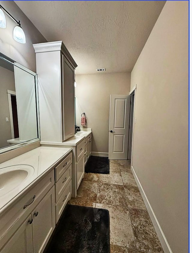 bathroom with vanity and a textured ceiling