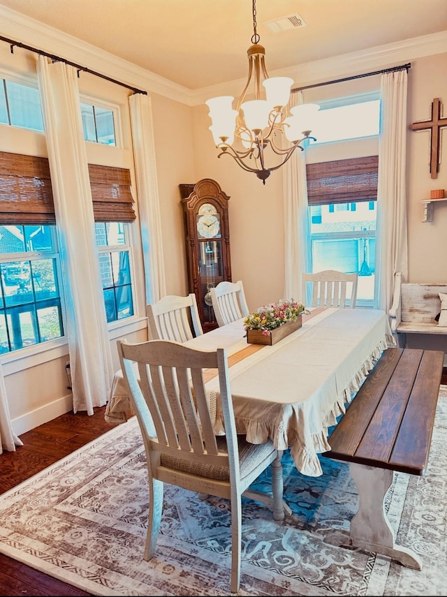 dining space featuring a wealth of natural light, wood finished floors, visible vents, and an inviting chandelier