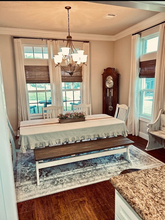 dining room with a chandelier, wood finished floors, visible vents, and ornamental molding