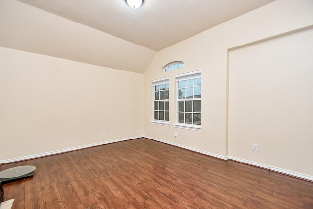 spare room featuring hardwood / wood-style flooring and lofted ceiling