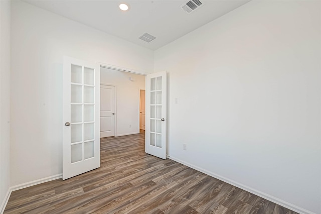 empty room featuring dark hardwood / wood-style floors and french doors