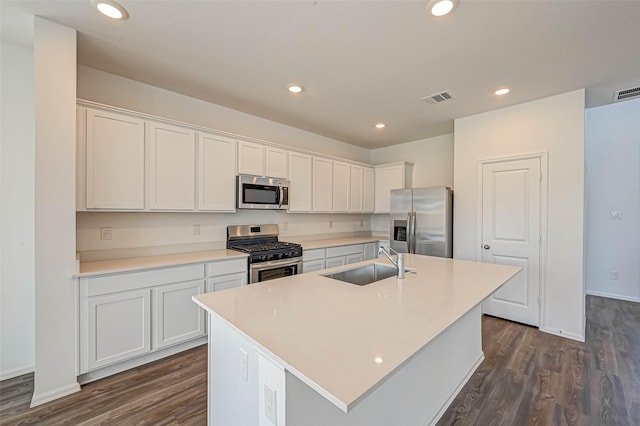 kitchen featuring white cabinetry, stainless steel appliances, sink, and a center island with sink