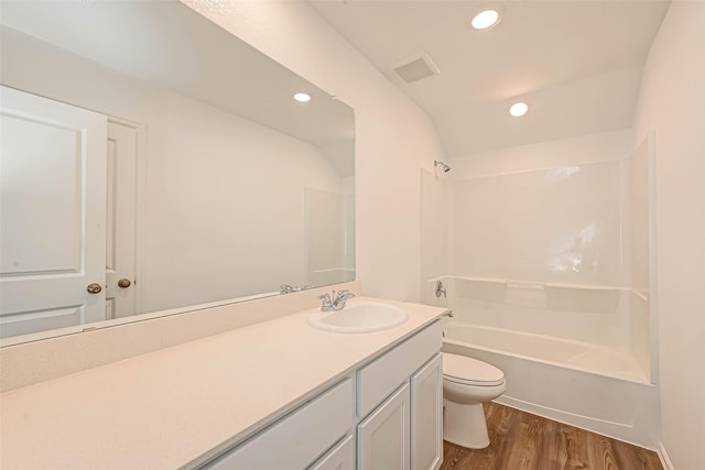 full bathroom with bathtub / shower combination, toilet, wood-type flooring, vaulted ceiling, and vanity