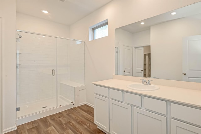 bathroom featuring hardwood / wood-style flooring, vanity, and walk in shower