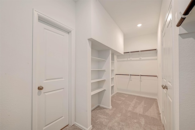 walk in closet featuring light carpet