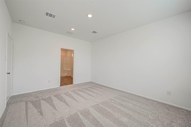 spare room featuring light colored carpet