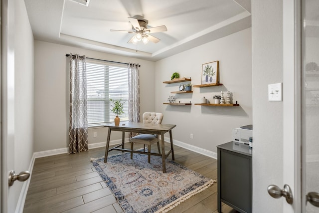 office area featuring a tray ceiling, ceiling fan, and hardwood / wood-style flooring