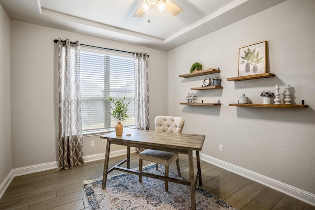 office space featuring hardwood / wood-style flooring, ceiling fan, and a tray ceiling