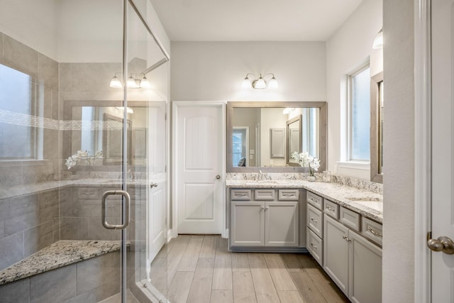 bathroom featuring hardwood / wood-style flooring, vanity, and a shower with shower door