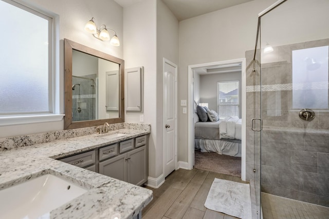 bathroom with hardwood / wood-style flooring, vanity, and a shower with shower door