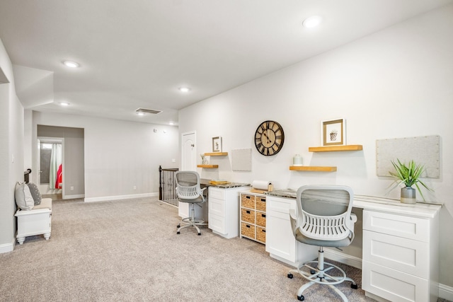 office space with built in desk and light colored carpet