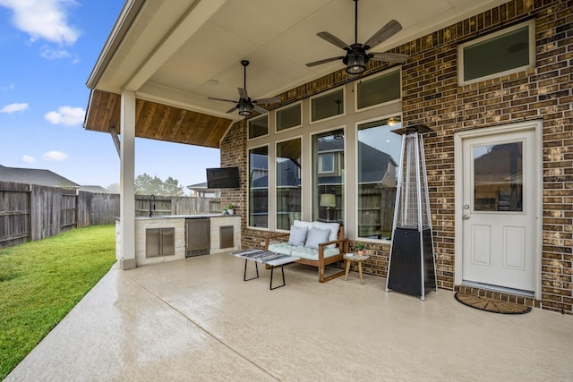 view of patio / terrace featuring exterior kitchen, sink, and ceiling fan