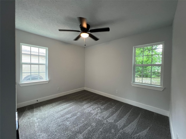 carpeted empty room featuring ceiling fan, a wealth of natural light, and a textured ceiling