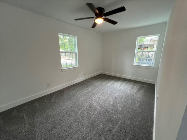 spare room with ceiling fan and dark carpet