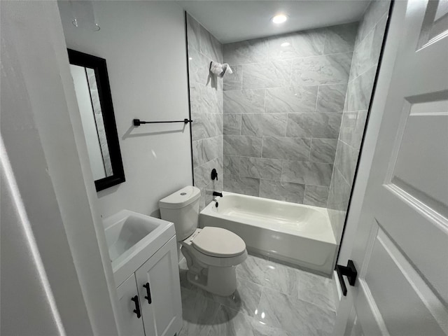 full bathroom featuring tiled shower / bath combo, vanity, and toilet