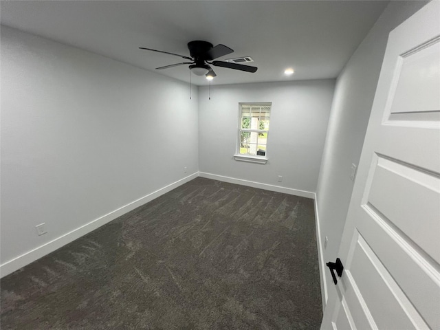 spare room with ceiling fan and dark colored carpet