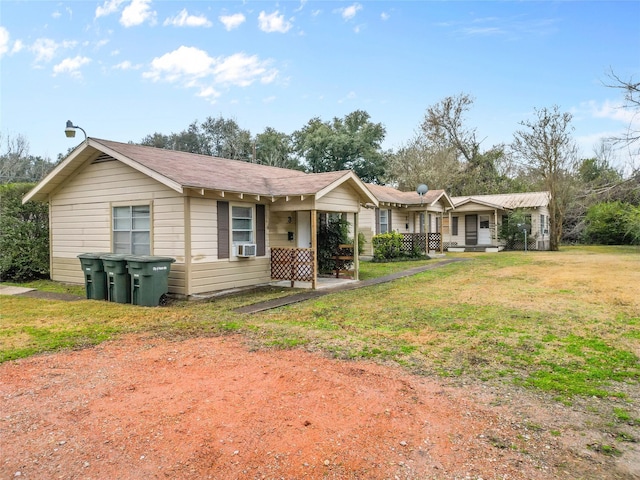 view of front of property featuring cooling unit and a front lawn