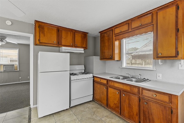 kitchen featuring sink, white appliances, light tile patterned floors, ceiling fan, and a textured ceiling