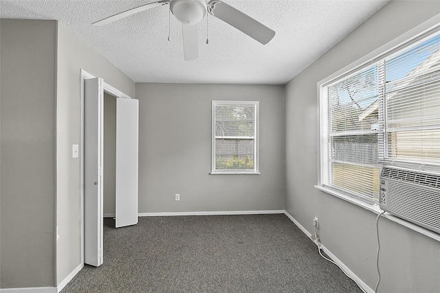 unfurnished bedroom with cooling unit, a textured ceiling, ceiling fan, and dark colored carpet