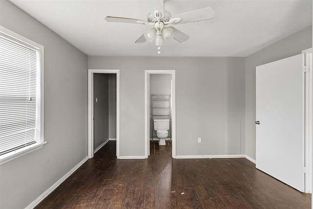 unfurnished bedroom with dark hardwood / wood-style floors, a spacious closet, ceiling fan, ensuite bath, and a closet