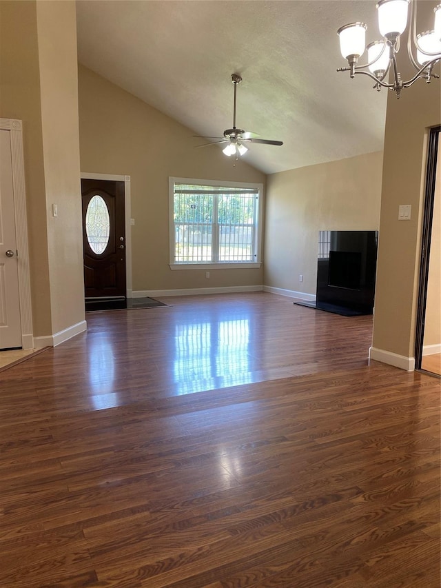 unfurnished living room featuring lofted ceiling, ceiling fan with notable chandelier, and dark hardwood / wood-style flooring