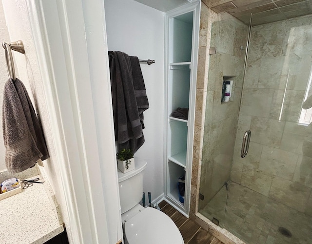 bathroom with a shower with door and toilet