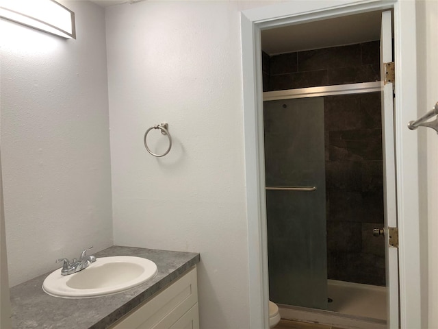 bathroom featuring vanity, toilet, and walk in shower