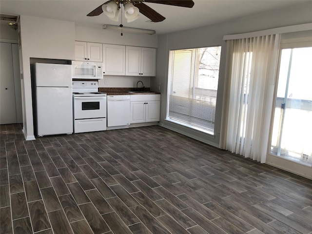 kitchen featuring white cabinetry, white appliances, dark hardwood / wood-style floors, and sink