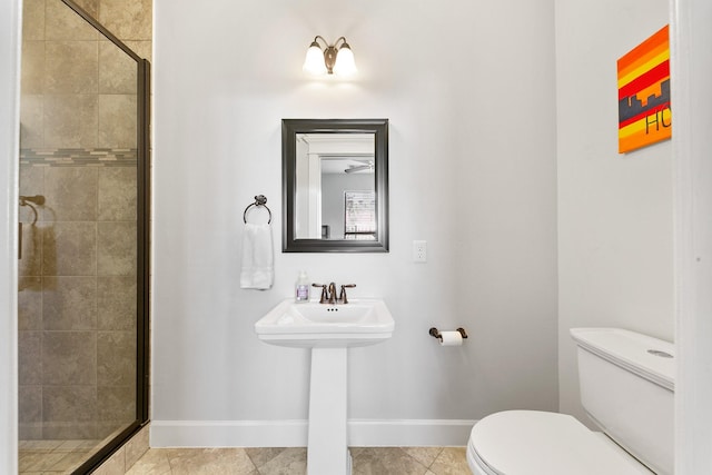 bathroom with tile patterned floors, toilet, and a shower with shower door