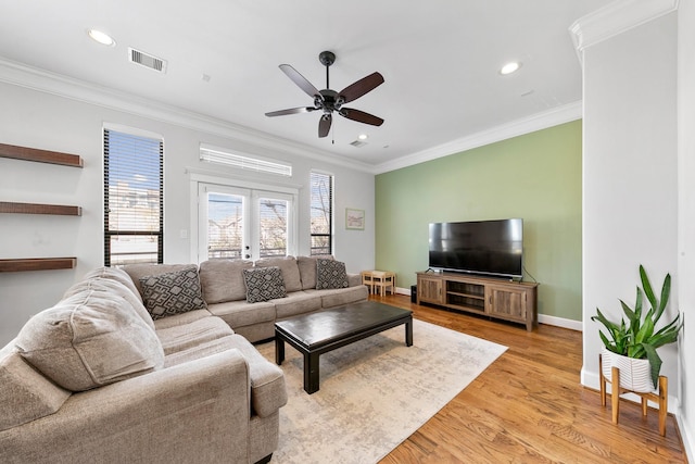 living room with ornamental molding, light hardwood / wood-style flooring, ceiling fan, and french doors