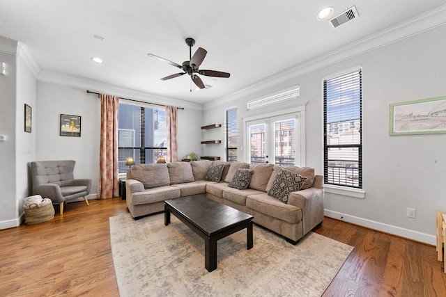 living room featuring hardwood / wood-style flooring, crown molding, ceiling fan, and french doors