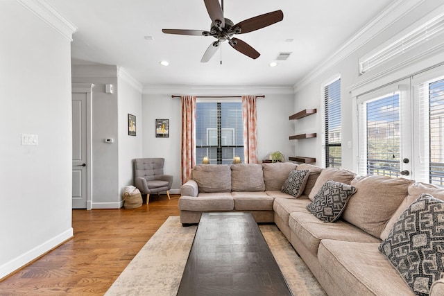 living room with ornamental molding, light hardwood / wood-style floors, and ceiling fan