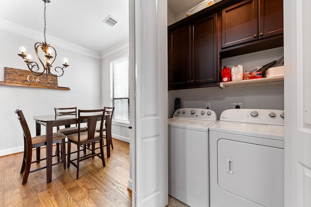 laundry area featuring cabinets, crown molding, independent washer and dryer, and light hardwood / wood-style flooring