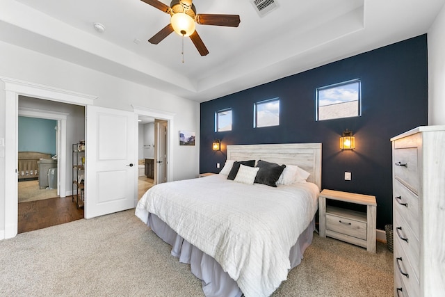 bedroom featuring carpet floors, a raised ceiling, and ceiling fan