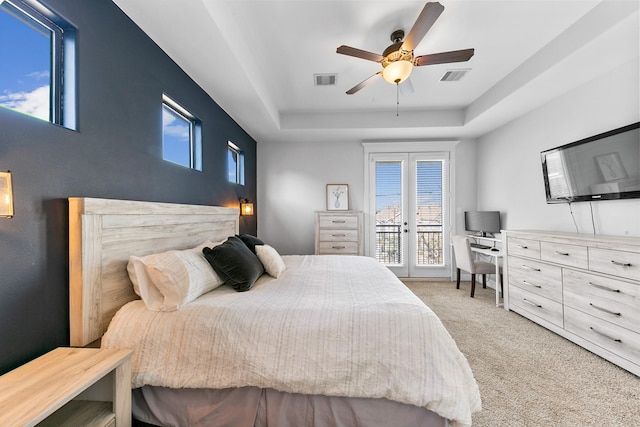 carpeted bedroom featuring a raised ceiling, access to outside, ceiling fan, and french doors