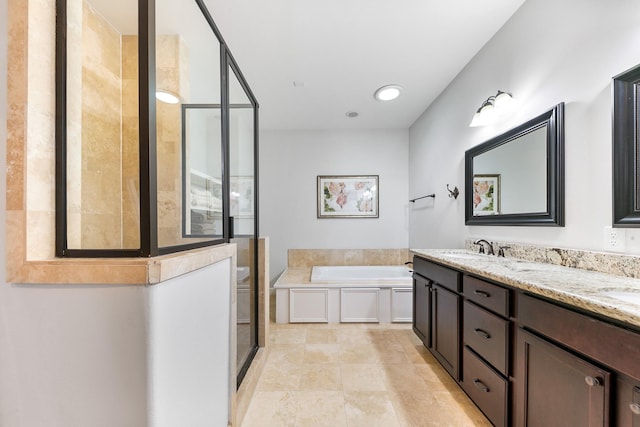 bathroom featuring vanity and independent shower and bath