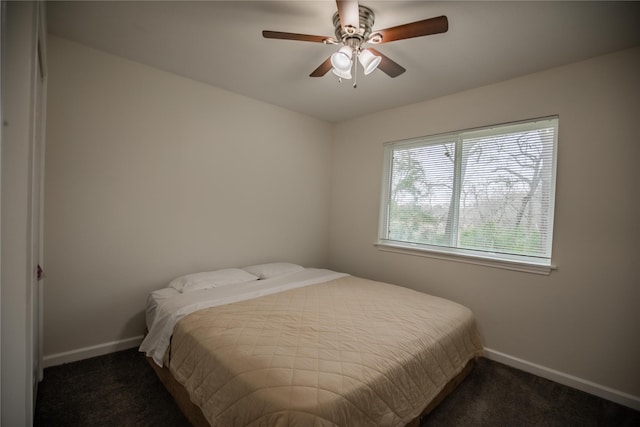 bedroom with ceiling fan and dark carpet