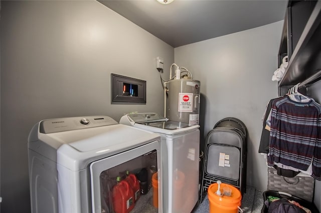 clothes washing area with separate washer and dryer and water heater