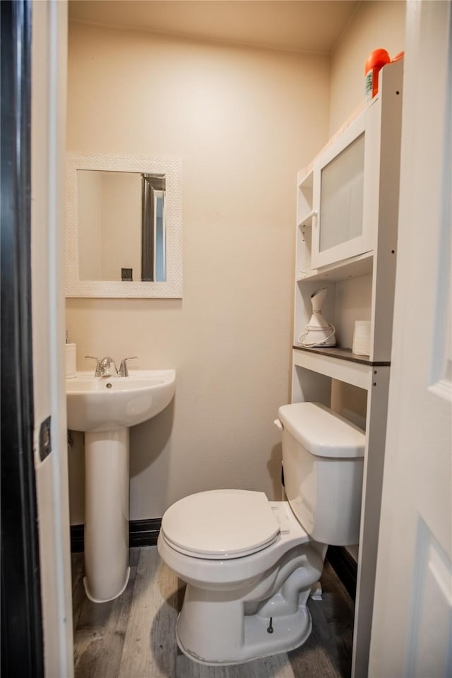 bathroom featuring wood-type flooring and toilet