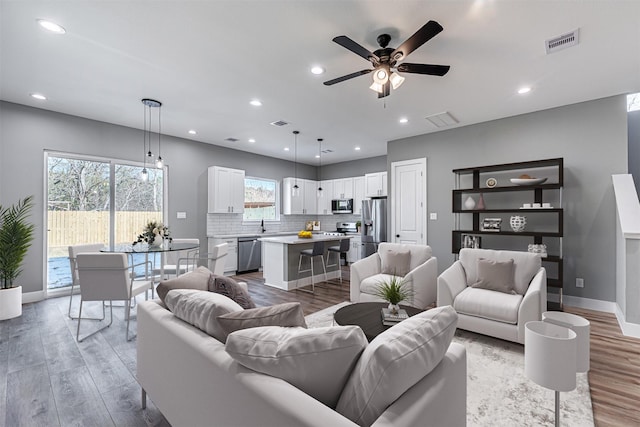 living room featuring ceiling fan and light hardwood / wood-style floors