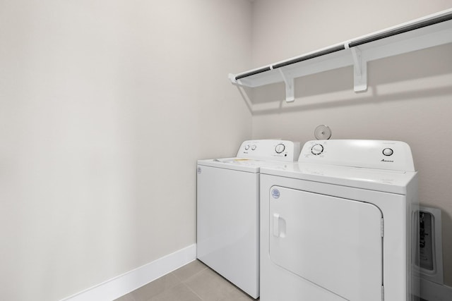 laundry room featuring washing machine and dryer and light tile patterned flooring