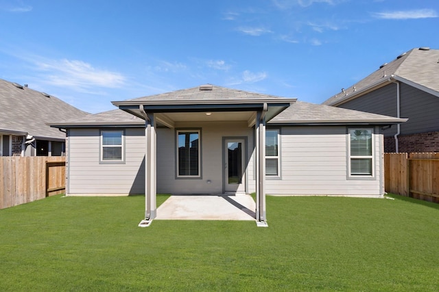 rear view of house featuring a lawn and a patio