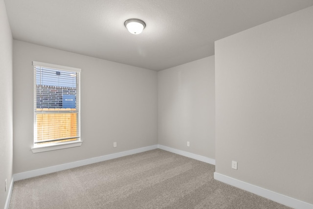 carpeted spare room with baseboards