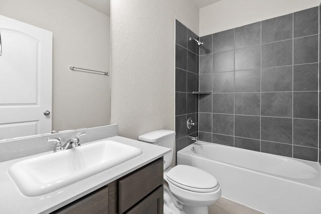 bathroom featuring shower / bathtub combination, toilet, vanity, and a textured wall